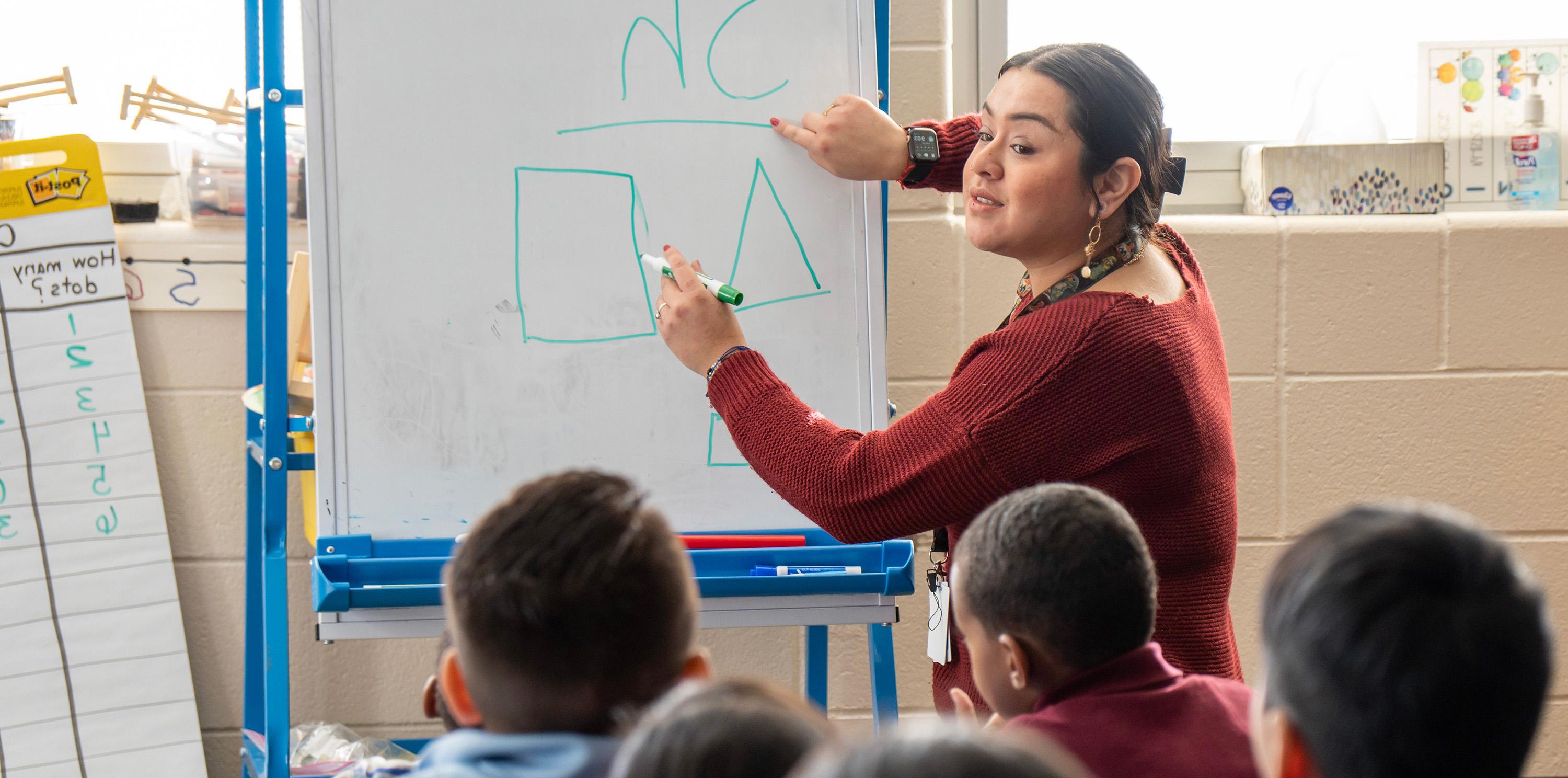 Teacher pointing at shapes in front of young 学生